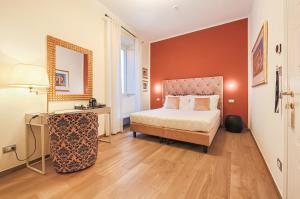 1 dormitorio con cama, mesa y espejo en Canto degli Aranci, en Florencia