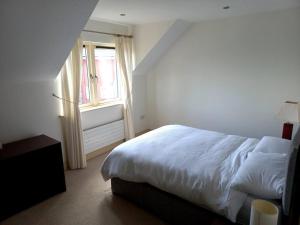 sypialnia z białym łóżkiem i oknem w obiekcie Home with views on the bay w mieście Greenane
