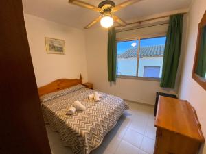 Un dormitorio con una cama con dos zapatos. en Hotel El Pescador, en Sant Pere Pescador
