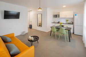 a living room and kitchen with a couch and a table at All Suites Appart Hôtel - Le Havre Centre - Les docks in Le Havre
