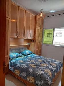 a bedroom with a bed and cabinets and a window at Hi Home in Meknès