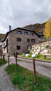 un edificio di mattoni con una recinzione di fronte di Apartamentos L´Era de Baix a Barruera