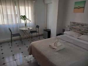 a bedroom with a bed and a table and chairs at Guests House River in Málaga