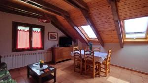 a dining room with a table and chairs and windows at Apartamentos L´Era de Baix in Barruera