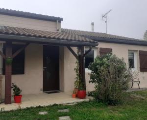 uma casa com um alpendre e uma porta preta em CHEZ MAMINE em Castanet-Tolosan
