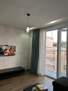 a living room with a large window and a couch at 3 minutes walk from the sea in Batumi