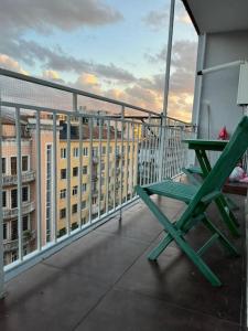 a green chair sitting on top of a balcony at 3 minutes walk from the sea in Batumi