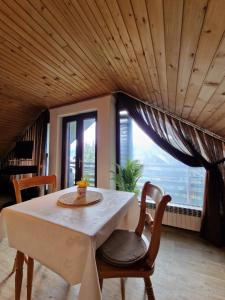 een eetkamer met een tafel en stoelen en een groot raam bij Vila Nana Bled Apartments & Rooms in Bled