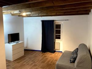 Una sala de estar con un sofá y un televisor. en Duplex rare avec terrasse vue à 360 Théâtre, en Orange