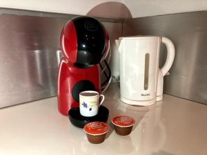 Una cafetera roja sentada en un mostrador con tazas en Duplex rare avec terrasse vue à 360 Théâtre, en Orange 13 fotos más