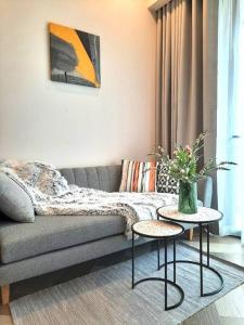 Una sala de estar con un sofá y dos mesas. en Luxury Condo In Metropole Thu Thiem Sai Gon, en Ho Chi Minh
