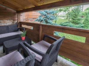 a patio with wicker chairs and a table and a window at Villa Rubcic in Rakovica