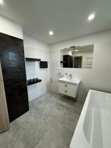 ein Badezimmer mit einer Badewanne und einem Waschbecken in der Unterkunft Apartmán Komenského 14, Bojnice in Bojnice
