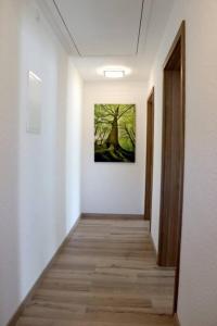 a hallway with a painting of a tree on the wall at Ferienwohnung Hof-Waldwinkel I 