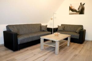 a living room with two couches and a coffee table at Ferienwohnung Hof-Waldwinkel I 