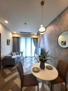Una sala de estar con una mesa y sillas y un sofá. en Luxury Condo In Metropole Thu Thiem Sai Gon, en Ho Chi Minh