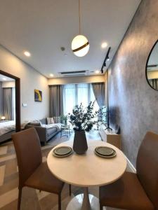 Una sala de estar con un jarrón de flores sobre una mesa. en Luxury Condo In Metropole Thu Thiem Sai Gon, en Ho Chi Minh