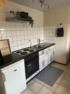 a kitchen with a stove and a sink at Voyago room relax ride in Cadier en Keer