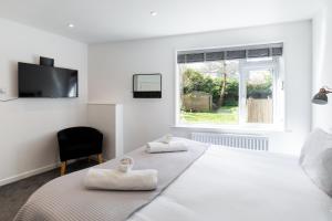 a white bedroom with a bed with towels on it at The Nook - Self Serviced Accommodation in St Ives