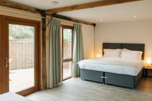 a bedroom with a bed and a large window at 2 Henham Barns in Beccles