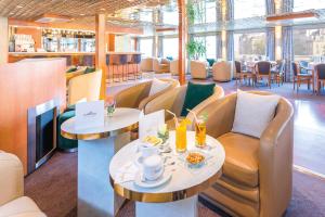 un restaurant avec des canapés, des tables et des chaises dans l'établissement Bateau Botticelli by CroisiEurope, à Paris