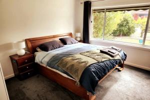 a bedroom with a large bed and a window at Charming Home Near Melbourne Airport & CBD in Melbourne