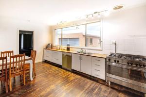 a kitchen with a table and a dining room at Charming Home Near Melbourne Airport & CBD in Melbourne