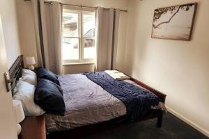 Schlafzimmer mit einem Bett und einem Fenster in der Unterkunft Charming Home Near Melbourne Airport & CBD in Melbourne