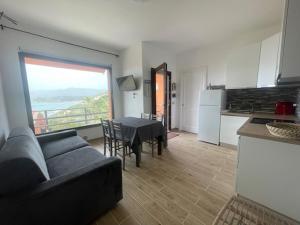 a living room with a couch and a table and a kitchen at DOMO A MARE in Magomadas