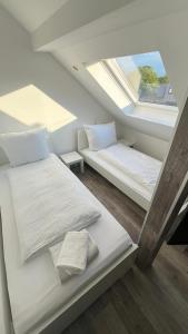 1 dormitorio en el ático con 2 camas y ventana en CITYLIFE Apartments Economy Osnabrück, en Osnabrück