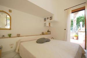 - une chambre blanche avec un lit et un oreiller dans l'établissement villa Il Gelsomino, à Termini
