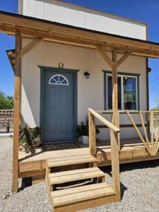 QuartzsiteTiny Cabin #19 American Trails的一座带蓝色门和木门廊的房子