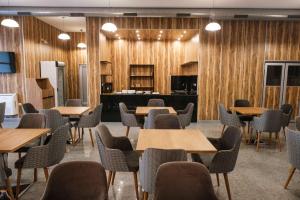 プロブディフにあるHOTEL BAYKOの木製の壁とテーブルと椅子が備わる会議室