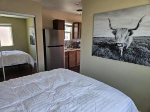 a bedroom with a painting of a cow on the wall at Tiny Cabin #19 American Trails in Quartzsite