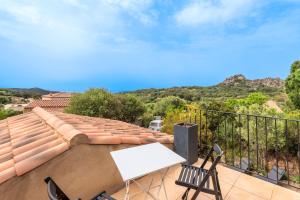a balcony with a table and chairs on a roof at Bergerie Piattone - Maison avec grand jardin in Pianottoli-Caldarello