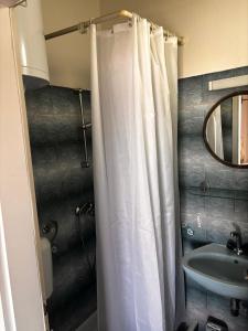 a bathroom with a shower curtain and a sink at Studio apartman More in Baška Voda
