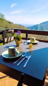 a blue table with plates and utensils on a table at Bee Freeride Biker house in Magliolo