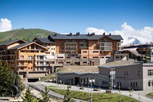 a group of buildings with mountains in the background at Résidence Daria-I Nor by les Etincelles in L'Alpe-d'Huez