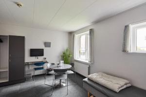 a living room with a table and a chair and a desk at Danhostel Esbjerg in Esbjerg