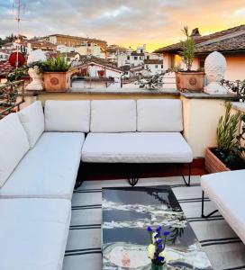 a couch on a balcony with a view of a city at Borgo San Jacopo Penthouse by 360Rentals in Florence
