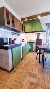a kitchen with green cabinets and a wooden floor at Bee Freeride Biker house in Magliolo +44 photos