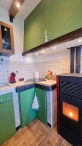a kitchen with green and blue cabinets and an oven at Bee Freeride Biker house in Magliolo