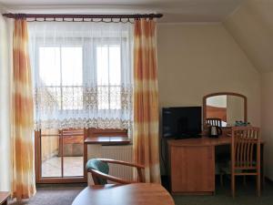 a living room with a desk and a window with a table at Willa Park in Zakopane