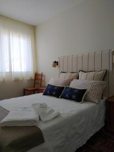 - une chambre dotée d'un grand lit avec des draps et des oreillers blancs dans l'établissement Vacacional muelle alto A Guarda, à A Guarda