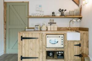 a kitchen with a green door and a microwave at 3 Henham Barns in Beccles