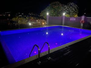 a swimming pool with blue lights in the night at D'Offay Seaview Apartments in Beau Vallon