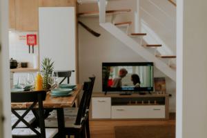 comedor con mesa y TV en Best Houses 17 - Casa da Saudade, en Atouguia da Baleia