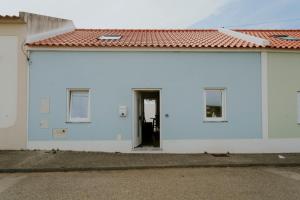 un edificio blanco con puerta y techo rojo en Best Houses 17 - Casa da Saudade, en Atouguia da Baleia