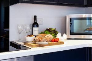 a cutting board with a bottle of wine and wine glasses at The Nook - Self Serviced Accommodation in St Ives