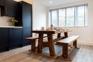 a dining room with a wooden table and benches at The Nook - Self Serviced Accommodation in St Ives